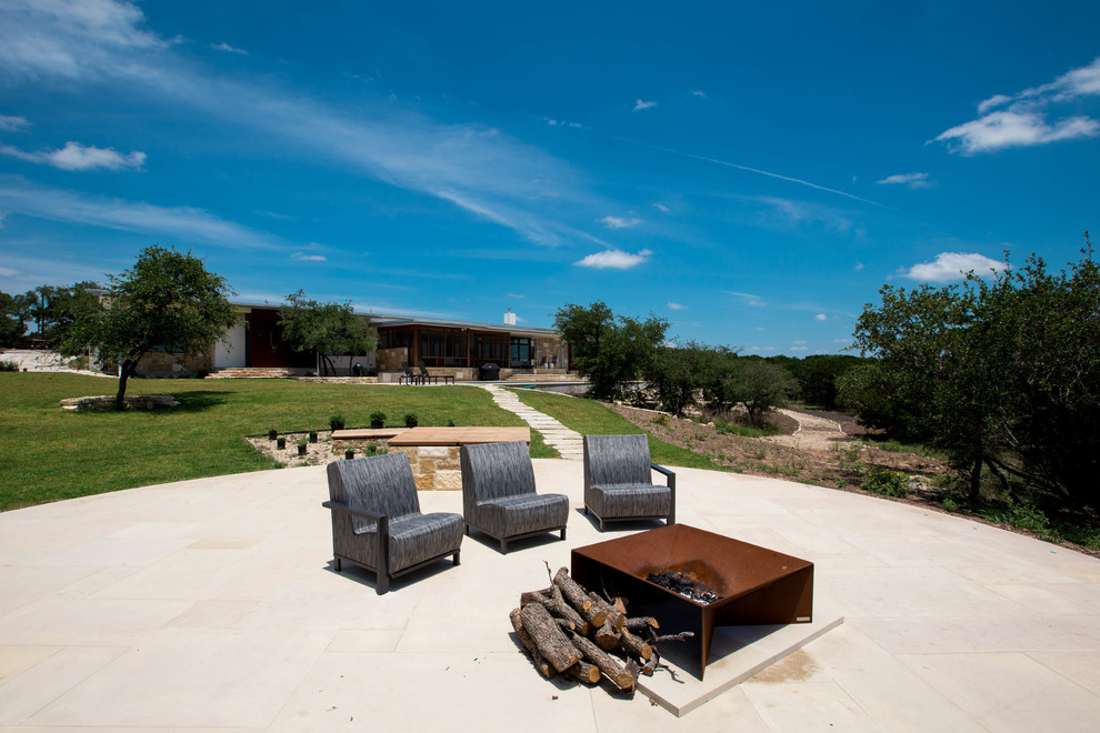 Foto di un grande giardino minimalista esposto in pieno sole dietro casa con un focolare e pavimentazioni in pietra naturale