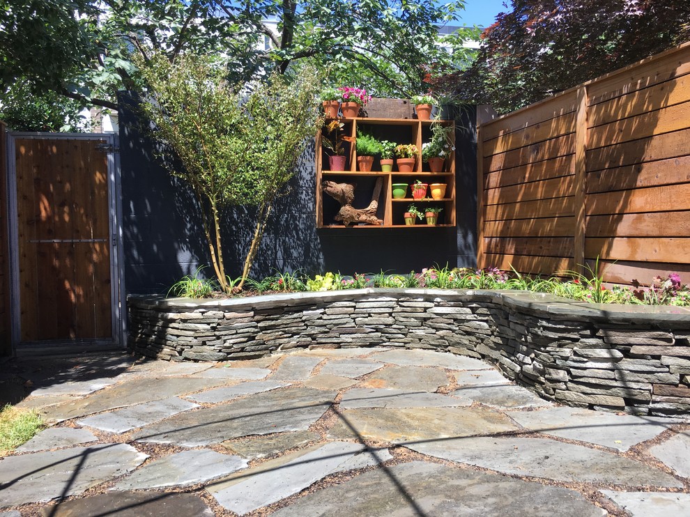 Idee per un piccolo giardino chic esposto a mezz'ombra dietro casa in estate con un muro di contenimento e pavimentazioni in pietra naturale