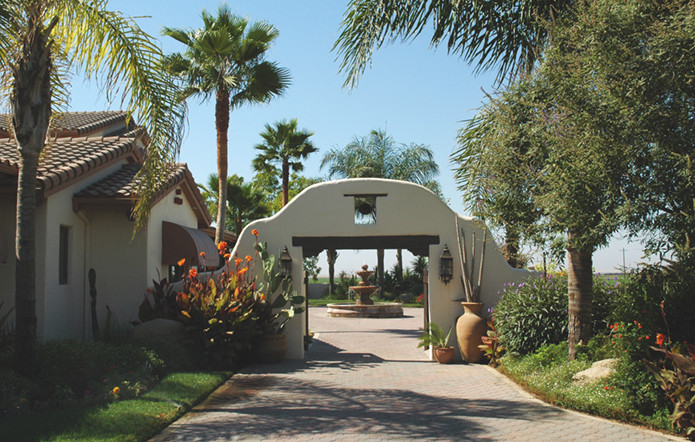 Modelo de acceso privado de estilo americano grande en patio delantero con exposición parcial al sol y adoquines de hormigón