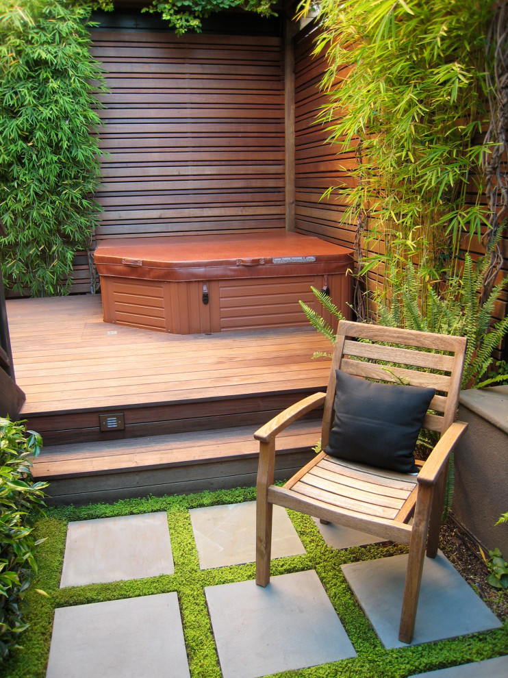 Aménagement d'un petit jardin sur cour classique avec des solutions pour vis-à-vis, une exposition ombragée et une terrasse en bois.