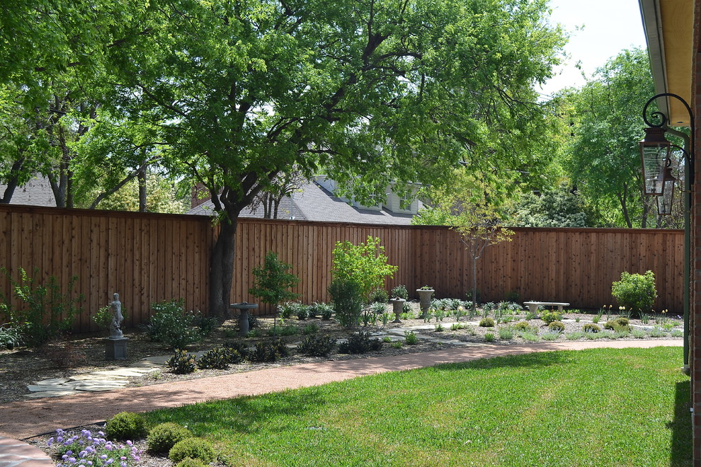 Cette image montre un grand aménagement d'entrée ou allée de jardin arrière traditionnel avec une exposition partiellement ombragée et des pavés en pierre naturelle.