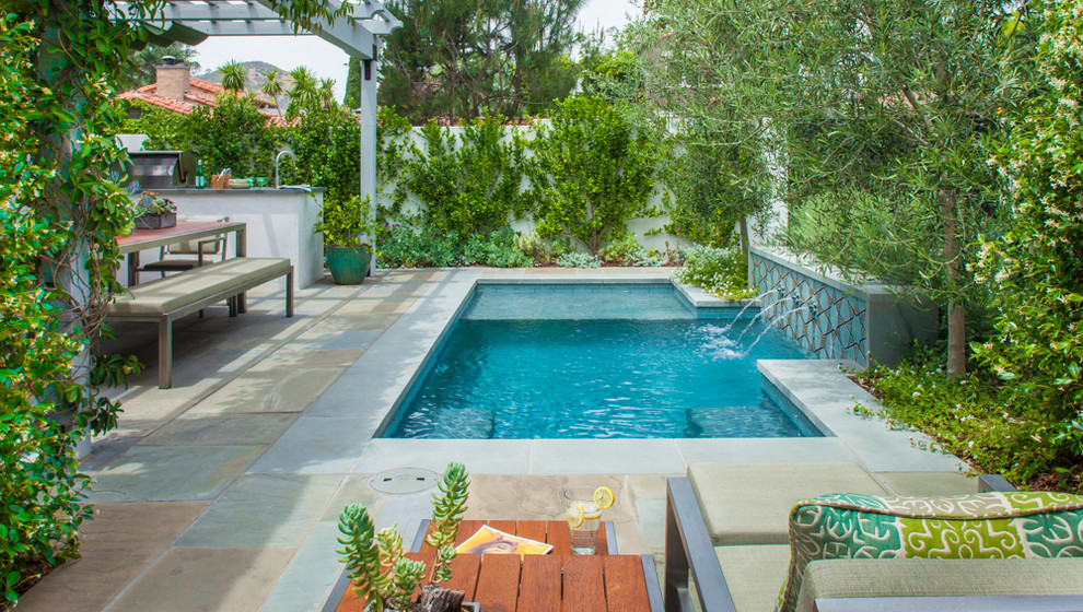 Design ideas for a small mediterranean back swimming pool in Los Angeles with natural stone paving.