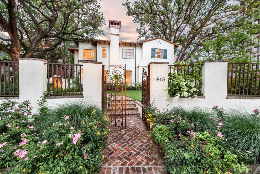 This is an example of a large mediterranean full sun front yard brick formal garden in Houston for spring.