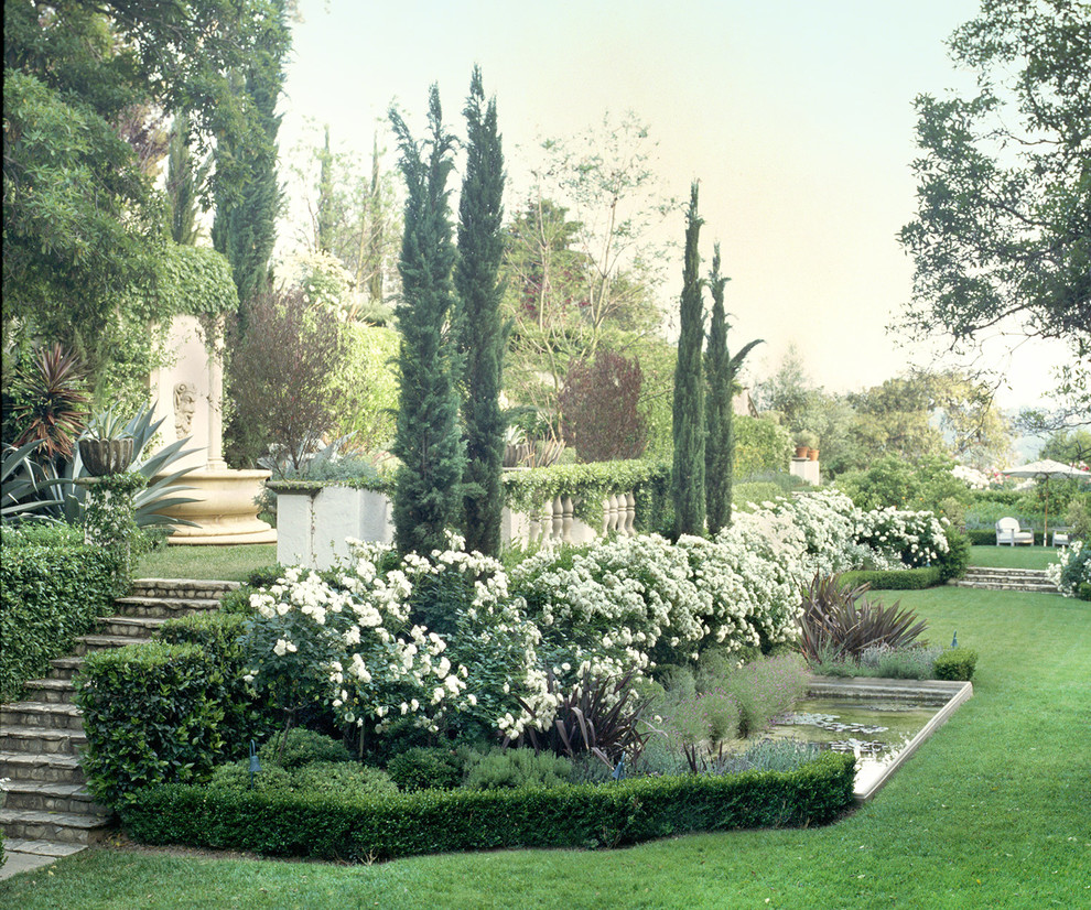 Ejemplo de jardín mediterráneo extra grande con jardín francés y fuente
