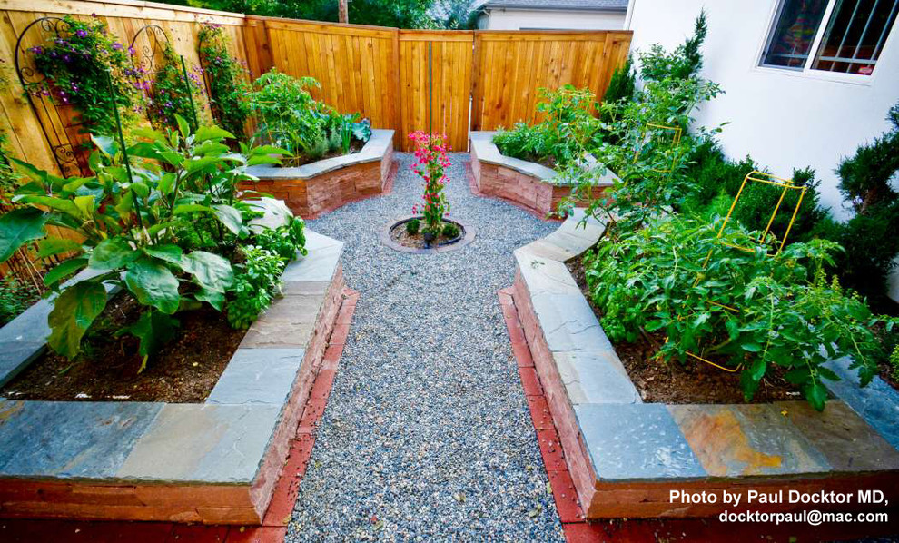 Idee per un piccolo giardino design esposto in pieno sole nel cortile laterale in estate con un muro di contenimento e ghiaia