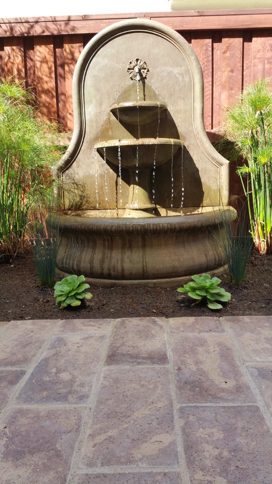 Inspiration for a mediterranean courtyard concrete paver water fountain landscape in San Diego.