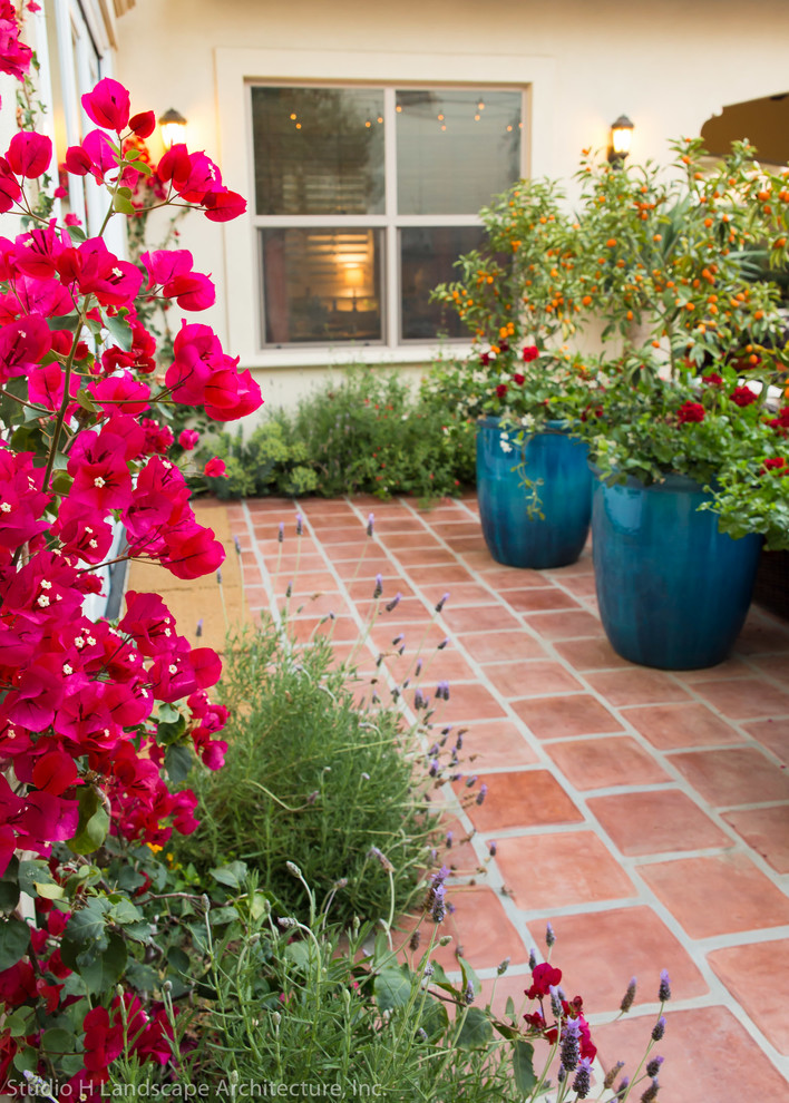 На фото: засухоустойчивый сад среднего размера на внутреннем дворе в средиземноморском стиле с местом для костра, полуденной тенью и мощением тротуарной плиткой с
