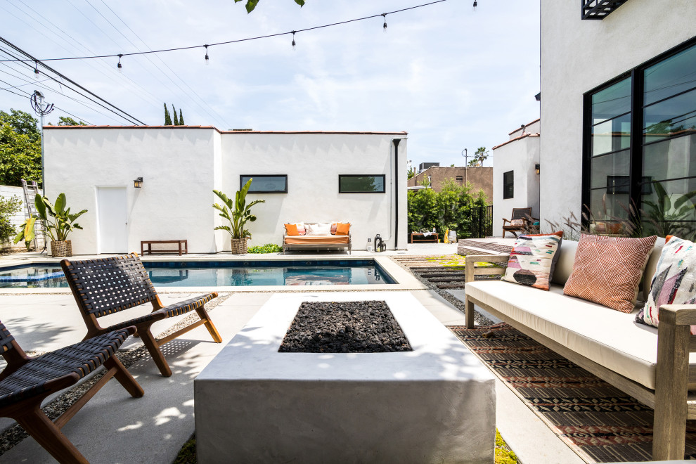Geometrischer, Mittelgroßer, Halbschattiger Mediterraner Garten hinter dem Haus mit Feuerstelle und Betonboden in Los Angeles