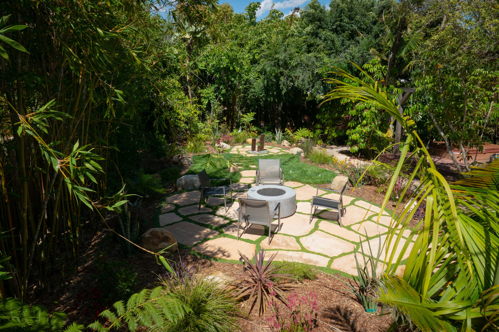 Exemple d'un jardin arrière avec un foyer extérieur et des pavés en pierre naturelle.