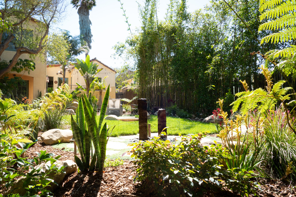 Exempel på en modern bakgård i full sol som tål torka, med en fontän och naturstensplattor
