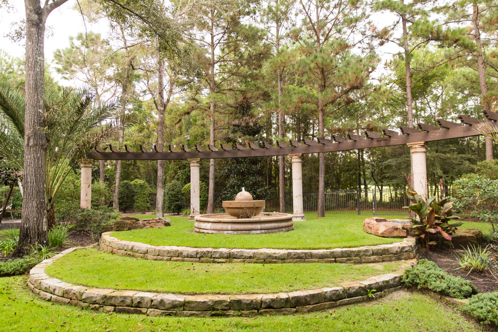 На фото: огромный участок и сад на заднем дворе в средиземноморском стиле с полуденной тенью и покрытием из каменной брусчатки