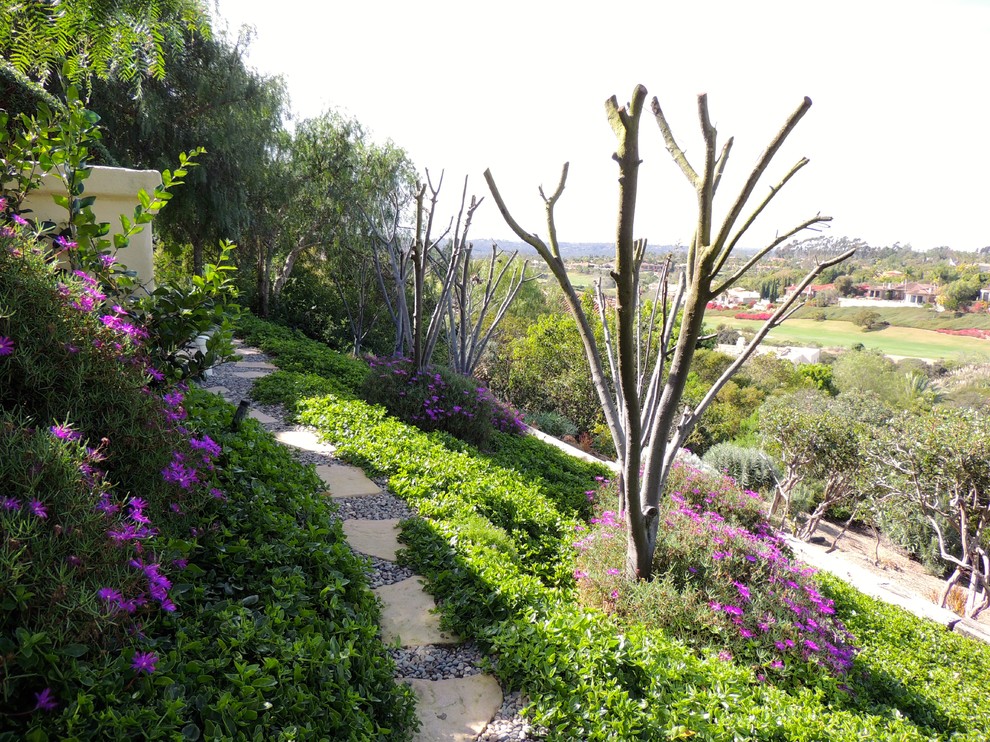Inredning av en medelhavsstil mycket stor trädgård i delvis sol i slänt på våren, med en trädgårdsgång och naturstensplattor