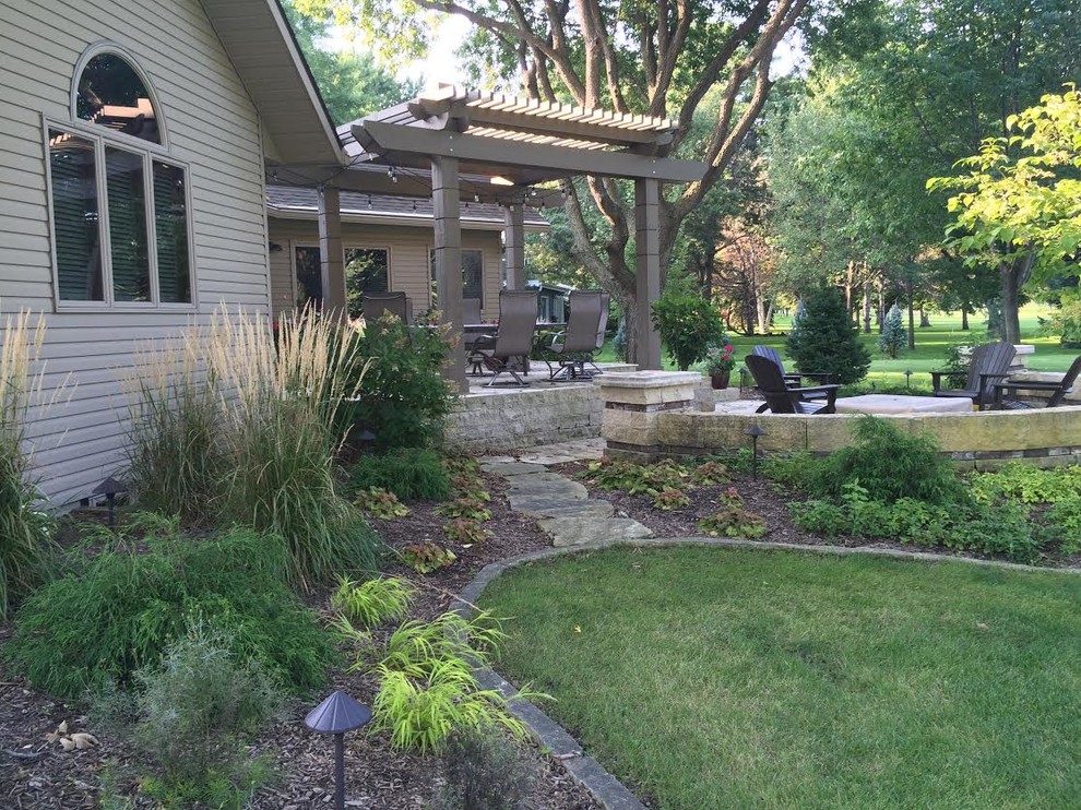 Diseño de jardín contemporáneo grande en patio trasero con brasero, exposición parcial al sol y adoquines de piedra natural
