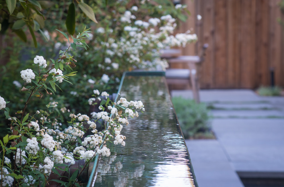 Idee per un piccolo giardino classico dietro casa in primavera con fontane e pavimentazioni in pietra naturale