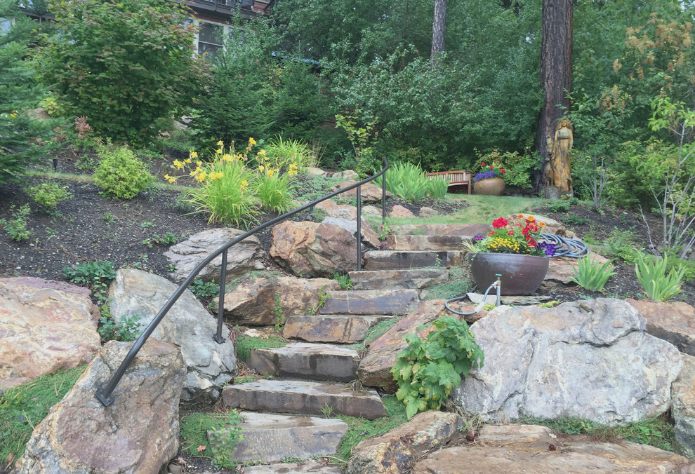 Inspiration for a medium sized rustic sloped garden in Seattle with a retaining wall and natural stone paving.