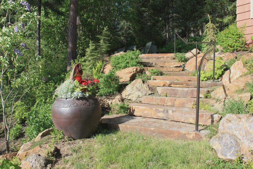 Photo of a mid-sized rustic hillside stone retaining wall landscape in Seattle.