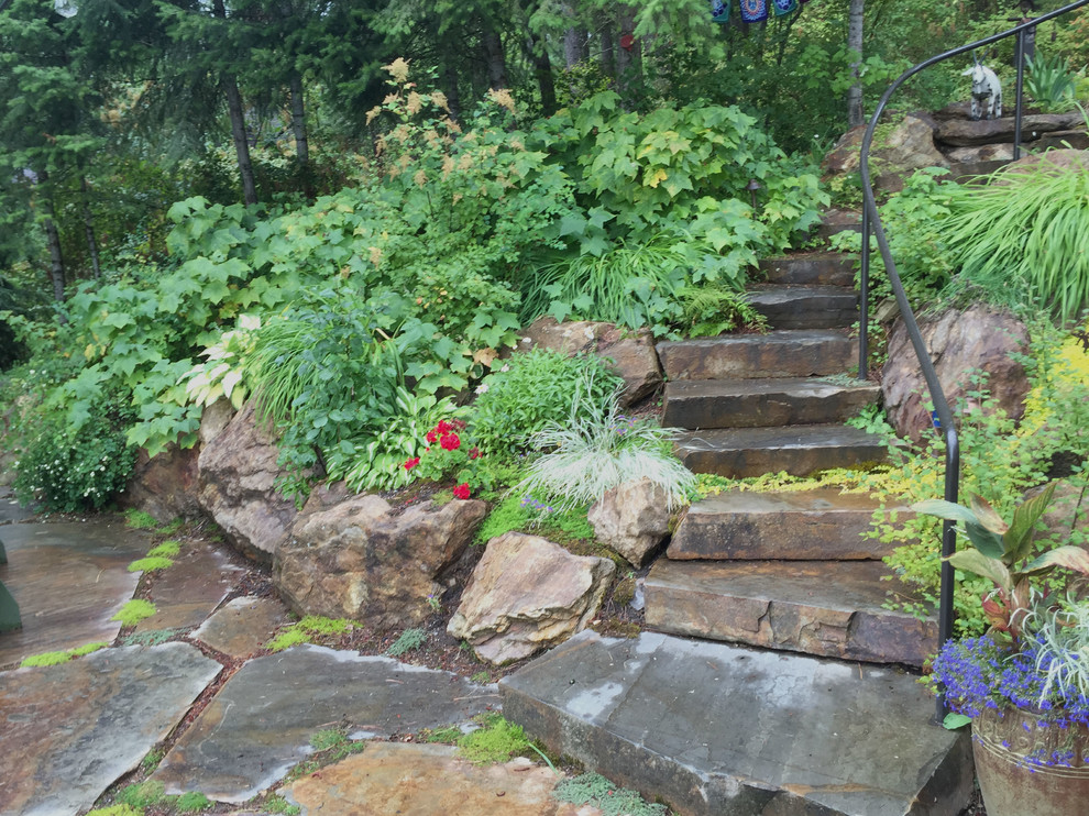 Exemple d'un jardin montagne de taille moyenne avec un mur de soutènement, une pente, une colline ou un talus et des pavés en pierre naturelle.