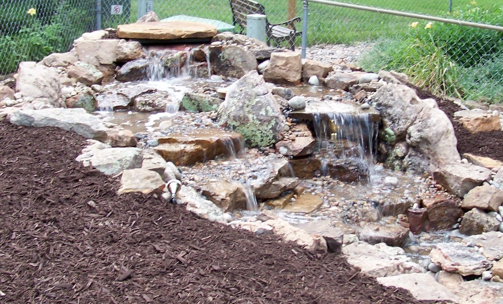 Inspiration for a small world-inspired back full sun garden for spring in Kansas City with a water feature and gravel.