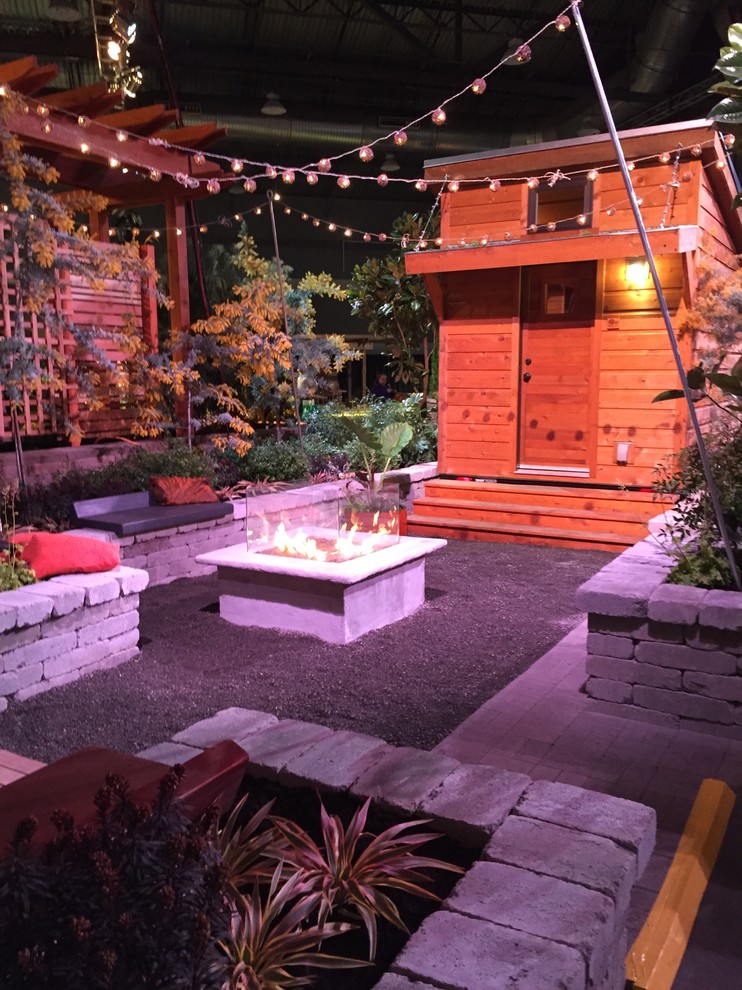 Modelo de jardín tradicional renovado de tamaño medio en patio trasero con brasero, exposición total al sol y gravilla