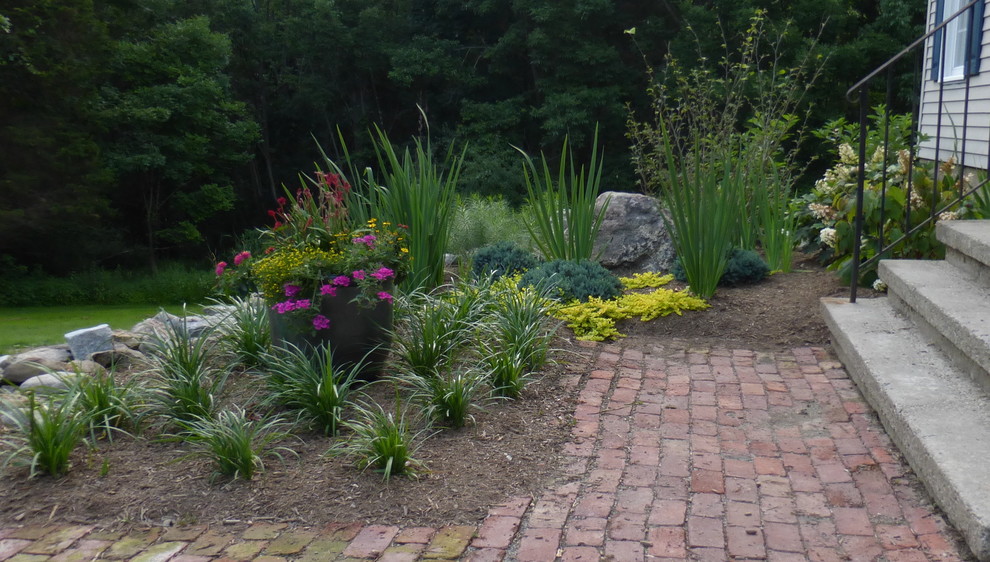 Ispirazione per un grande giardino xeriscape tradizionale esposto in pieno sole davanti casa in estate con pavimentazioni in mattoni e un giardino in vaso