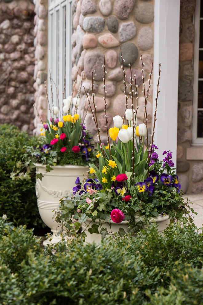 This is an example of a large traditional front garden for spring in Chicago with a potted garden.