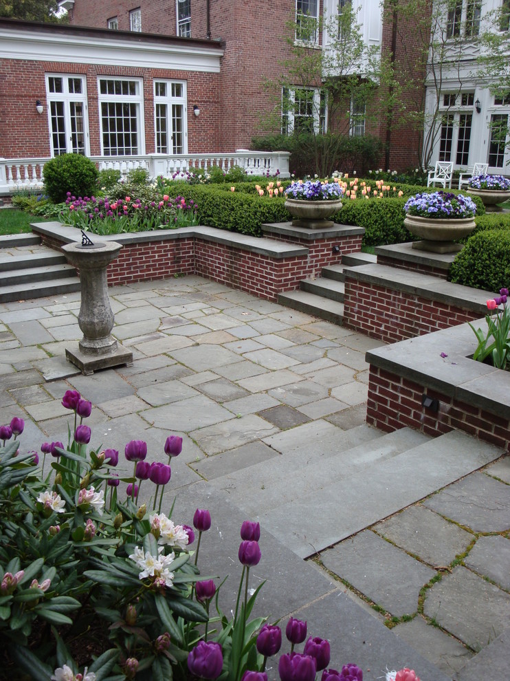 Imagen de jardín tradicional de tamaño medio en patio delantero con exposición total al sol y adoquines de piedra natural
