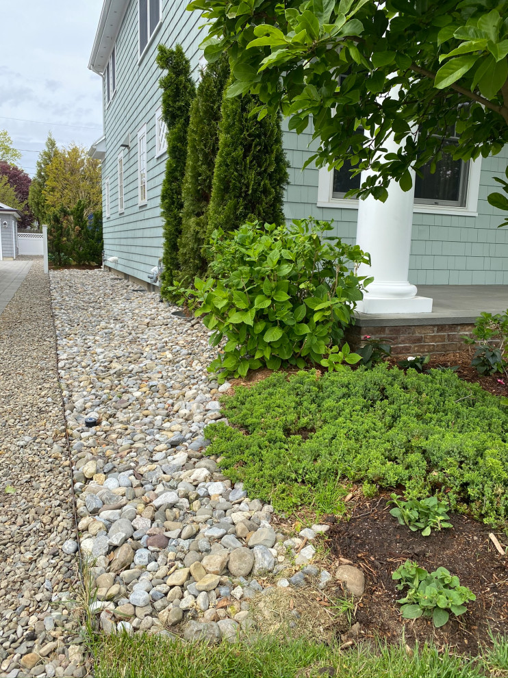 Design ideas for a traditional side yard river rock landscaping in New York.