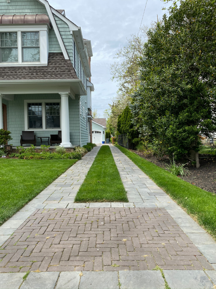 Стильный дизайн: участок и сад на переднем дворе в классическом стиле с подъездной дорогой, газонным бордюром и мощением клинкерной брусчаткой - последний тренд