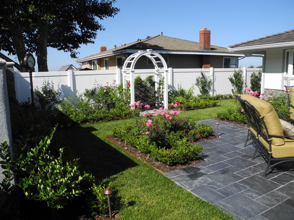 На фото: солнечный, летний регулярный сад среднего размера на переднем дворе в современном стиле с садовой дорожкой или калиткой, хорошей освещенностью и покрытием из каменной брусчатки