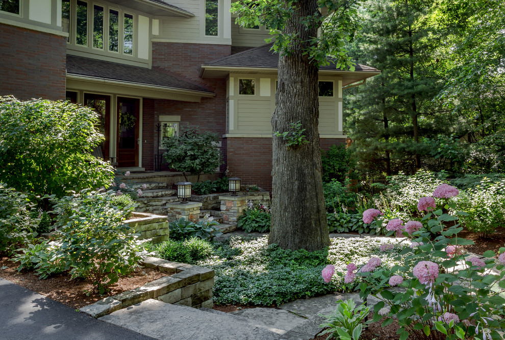 Design ideas for a large traditional shade front yard stone landscaping in Chicago for summer.