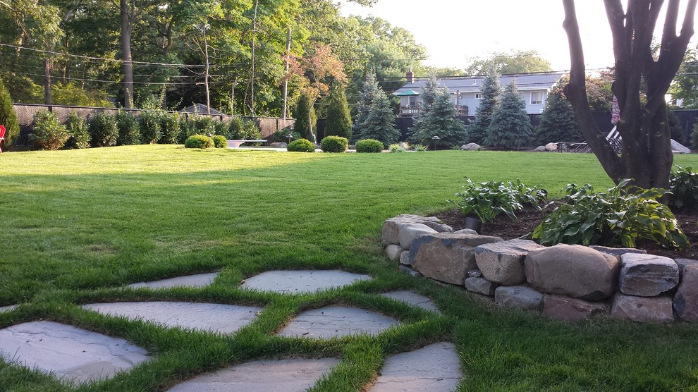 На фото: участок и сад среднего размера на заднем дворе в классическом стиле с полуденной тенью и мульчированием с