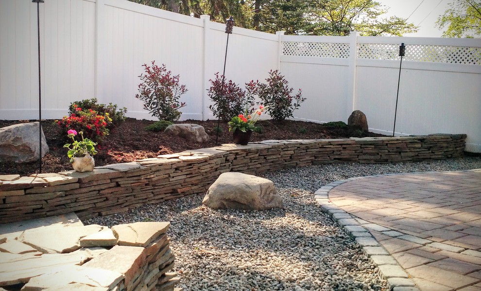 This is an example of a mid-sized eclectic full sun backyard gravel retaining wall landscape in Philadelphia.