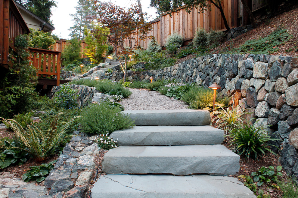 Large classic sloped garden in San Francisco with a garden path and natural stone paving.