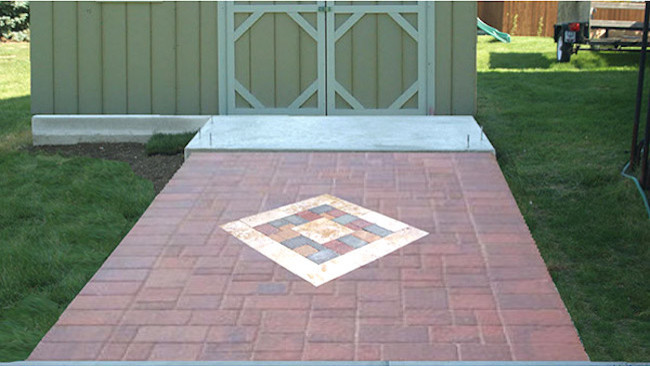 This is an example of a small contemporary back driveway fully shaded garden in Milwaukee with brick paving.