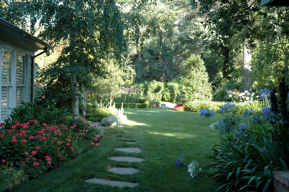 Ejemplo de jardín tradicional en patio trasero con exposición reducida al sol y adoquines de piedra natural
