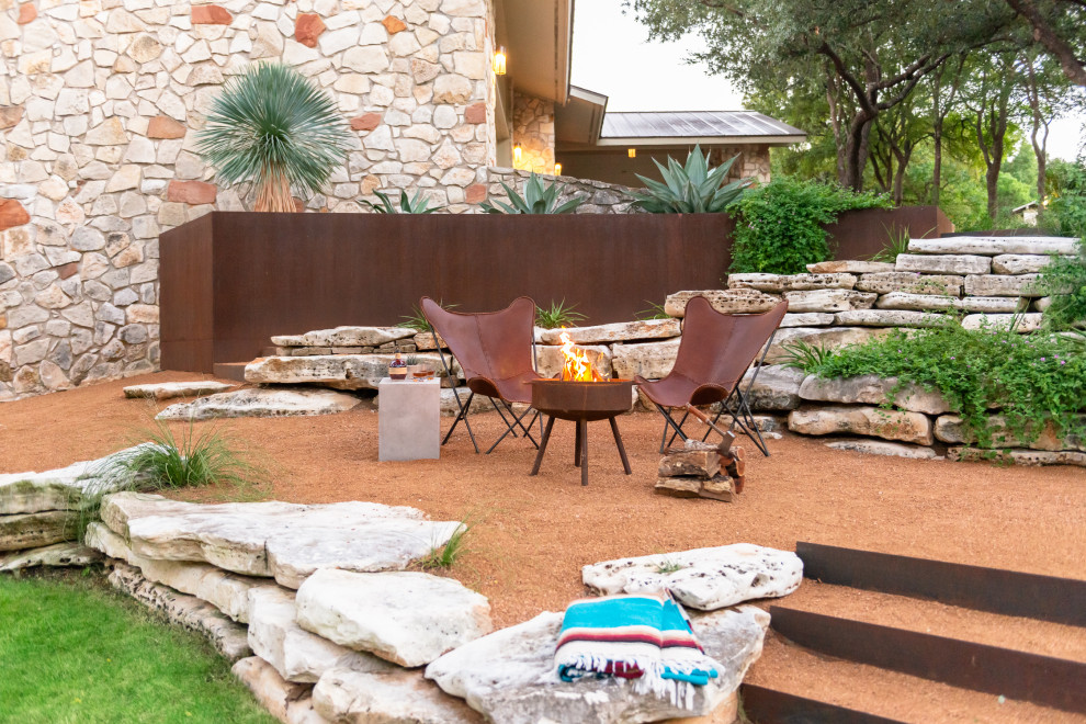 Design ideas for a large contemporary side xeriscape partial sun garden for autumn in Austin with a fire feature and gravel.