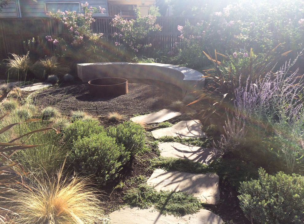 Esempio di un grande giardino mediterraneo esposto a mezz'ombra dietro casa con un focolare e ghiaia