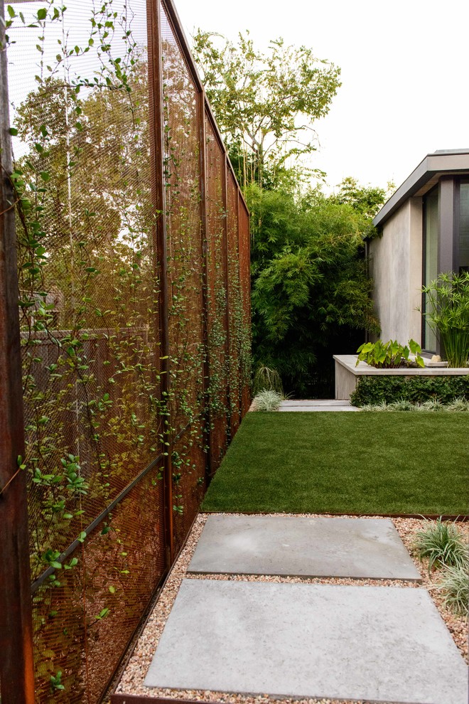Imagen de jardín minimalista de tamaño medio en primavera en patio lateral con exposición parcial al sol, gravilla, jardín francés y privacidad