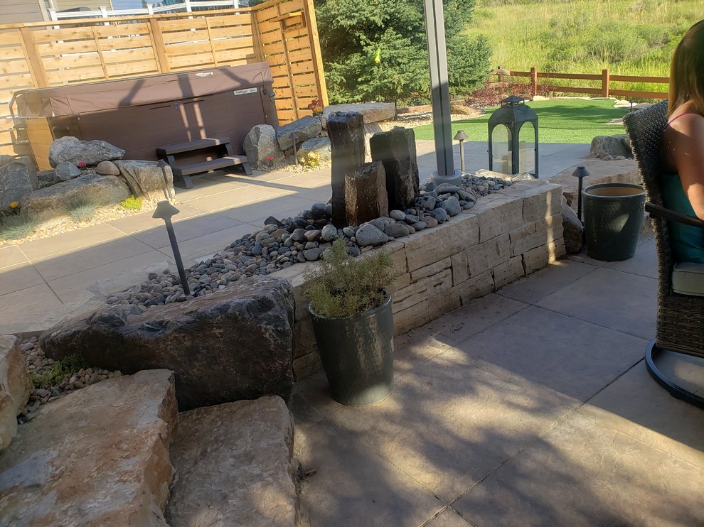 Imagen de jardín contemporáneo de tamaño medio en patio trasero con muro de contención y adoquines de piedra natural