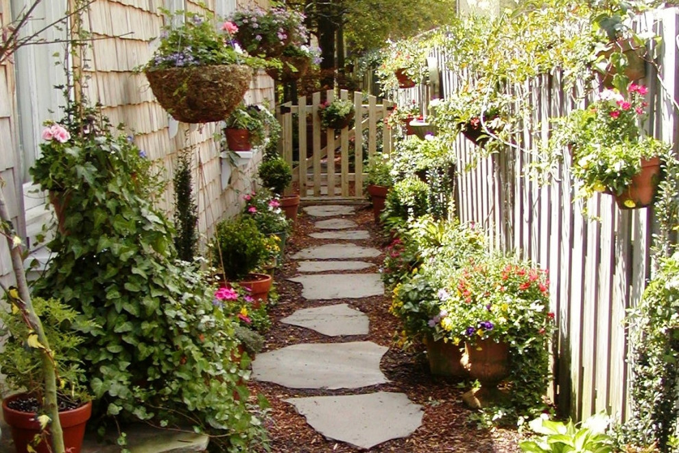 Klassischer Garten neben dem Haus mit Natursteinplatten und Holzzaun in Wilmington