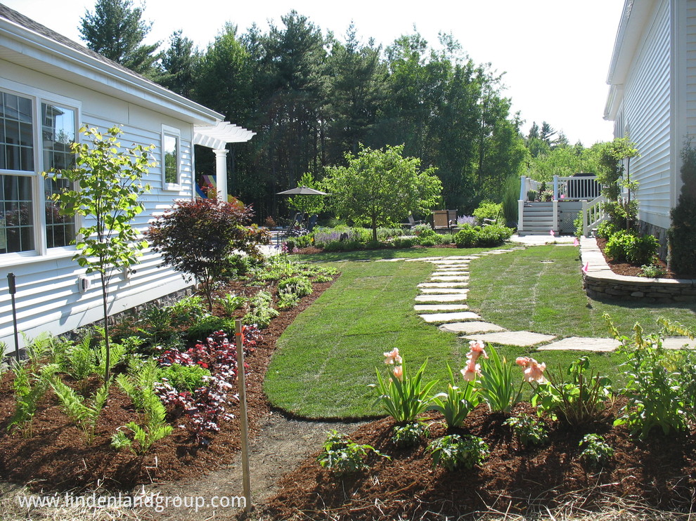 Ispirazione per un ampio giardino contemporaneo esposto in pieno sole dietro casa con un muro di contenimento e pavimentazioni in pietra naturale