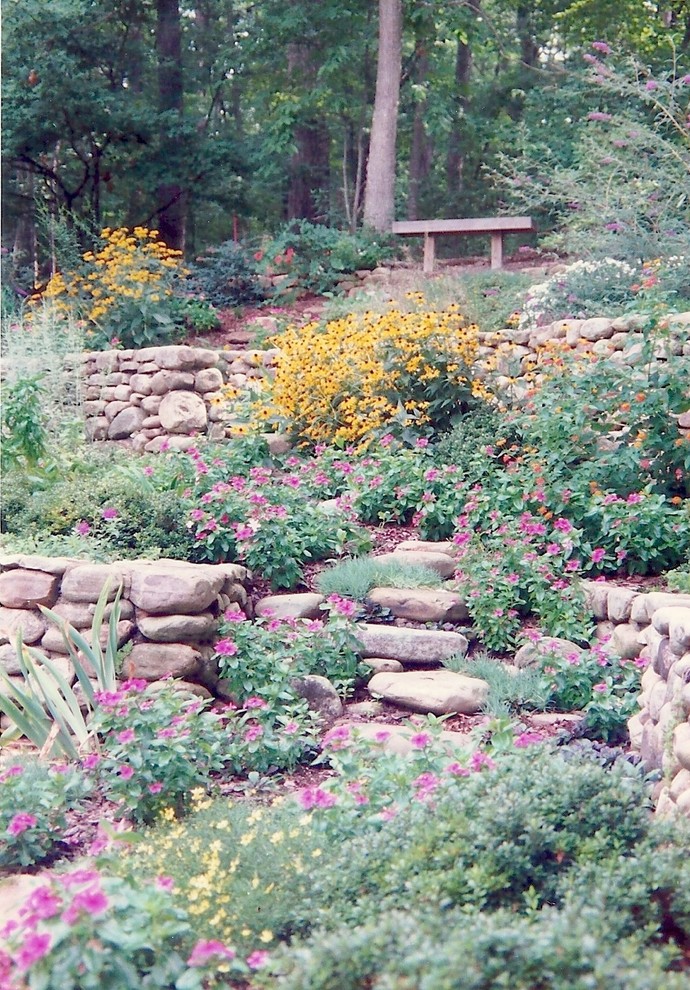 Exempel på en mellanstor rustik trädgård på sommaren, med en stödmur