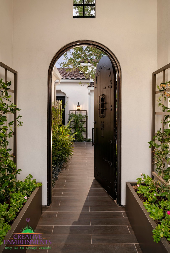 Großer, Halbschattiger Moderner Gartenkamin im Sommer, hinter dem Haus mit Betonboden und Metallzaun in Phoenix