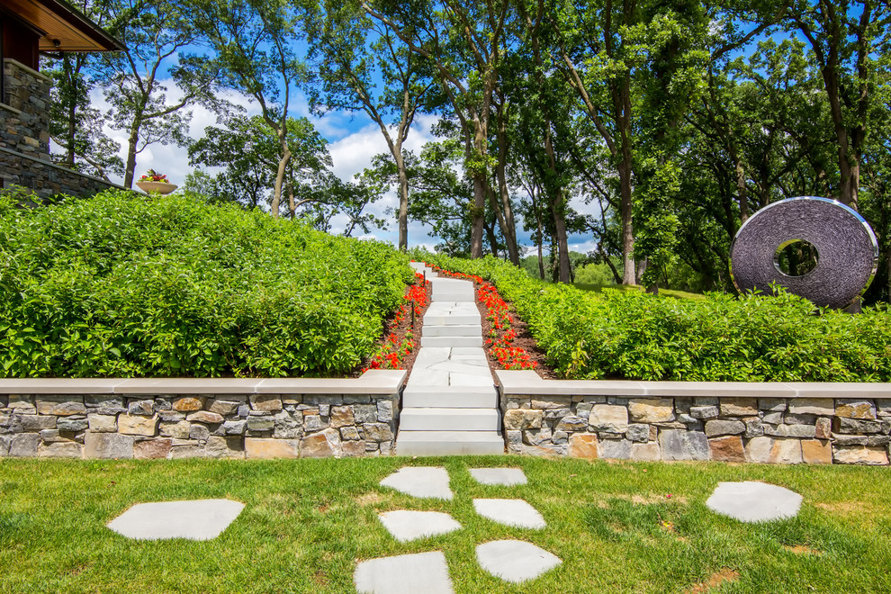 Foto de camino de jardín de estilo americano de tamaño medio en verano en patio trasero con jardín francés, exposición total al sol y adoquines de piedra natural