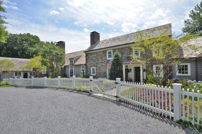 This is an example of a large farmhouse front driveway full sun garden for summer in New York with a garden path and gravel.