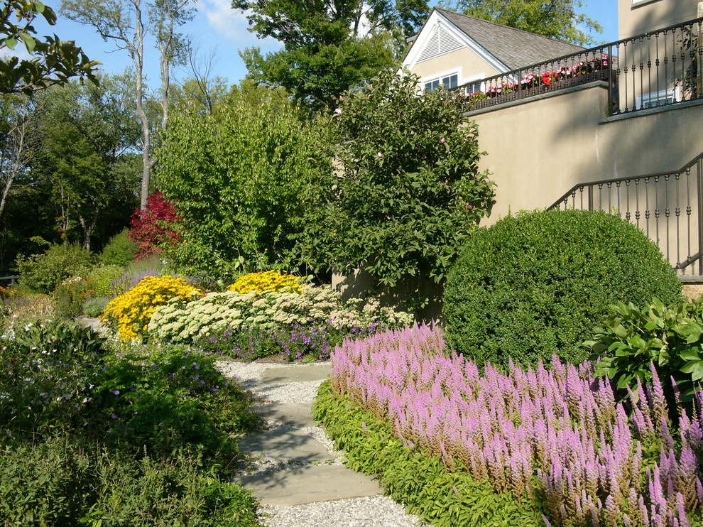 Idéer för att renovera en stor vintage formell trädgård i delvis sol framför huset, med en trädgårdsgång och grus