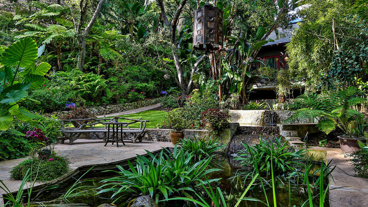 Halbschattiger, Großer Gartenteich hinter dem Haus mit Natursteinplatten in Los Angeles