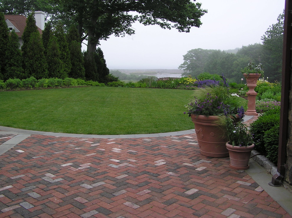 Esempio di un giardino classico dietro casa con un giardino in vaso e pavimentazioni in mattoni