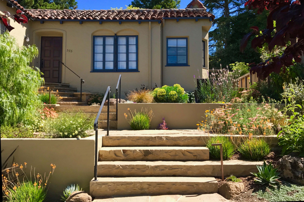 Immagine di un giardino mediterraneo esposto in pieno sole davanti casa con graniglia di granito