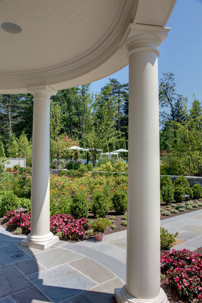 Foto de jardín clásico grande en verano en patio trasero con exposición parcial al sol, jardín francés y adoquines de piedra natural